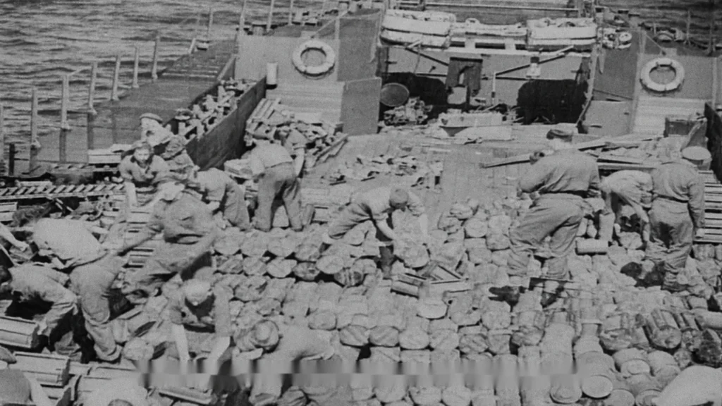 Photographie d’archive montrant des hommes rejetant à la mer des munitions non utilisées depuis un navire